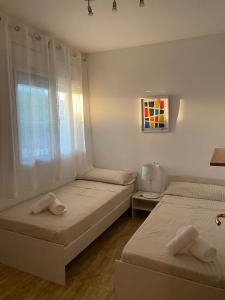 a bedroom with two beds and a window at Casa Mario & Amaya in Riumar