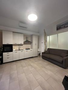 salon z kanapą i kuchnią w obiekcie V&M suite con jacuzzi w mieście Ostuni