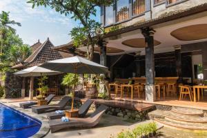 乌布Dewangga Ubud的一个带游泳池、椅子和遮阳伞的度假村