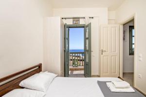 a bedroom with a bed and a view of the ocean at M. Houses 3 in Agios Romanos