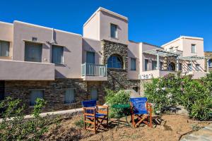 two chairs and a table in front of a building at M. Houses 3 in Agios Romanos