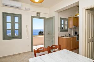 a kitchen with a table and a view of the ocean at M. Houses 3 in Agios Romanos