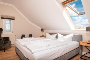 a bedroom with a large white bed with a window at Seehof 34 in Bansin