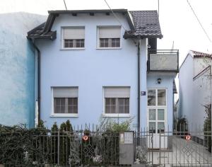 een blauw-wit huis met een hek bij Nusha's place in Zagreb