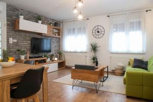 een woonkamer met een groene bank en een televisie bij Nusha's place in Zagreb