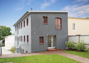 a gray house with red windows and a yard at Villa Bellevue 3 _App_ 12 in Ahlbeck