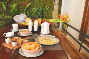 una mesa con platos de comida en una mesa en Sweet Harmony Hotel Boutique by Xarm Hotels, en Minca