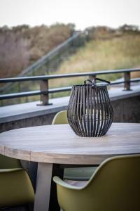 een vaas op een tafel met stoelen bij Sunny Terras, Cozy in the dunes in Cadzand