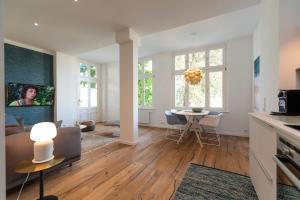 uma cozinha e sala de estar com mesa e cadeiras em Villa Doctores App 02 nur Erwachse em Heringsdorf