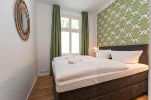 1 dormitorio con 1 cama grande, ventana y espejo en Villa Doctores App 02 nur Erwachse, en Heringsdorf