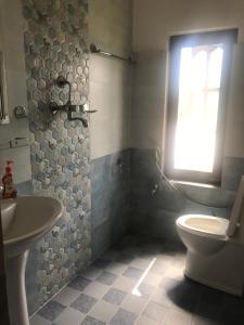 ein Bad mit einem WC, einem Waschbecken und einem Fenster in der Unterkunft Apartment at Balkot, Nepal in Thimi
