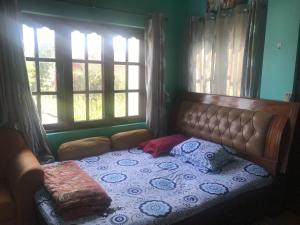 Bett in einem Zimmer mit 2 Fenstern in der Unterkunft Apartment at Balkot, Nepal in Thimi