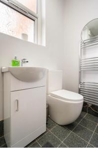 a white bathroom with a toilet and a sink at Luxury Flat in Moseley with Free Parking in Birmingham