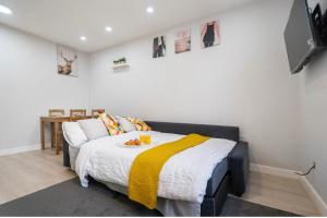 ein Schlafzimmer mit einem Bett mit einer gelben Decke darauf in der Unterkunft Luxury Flat in Moseley with Free Parking in Birmingham
