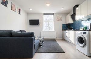 a living room with a couch and a washing machine at Luxury Flat in Moseley with Free Parking in Birmingham