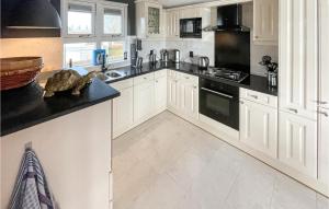 een keuken met witte kasten en zwarte aanrechtbladen bij Stunning Home In Workum With Kitchen in Workum