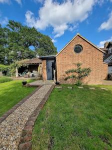 a brick house with a stone walkway in a yard at Garden Lodge close to Wakehurst and Kew Seed Bank Ardingly in Ardingly