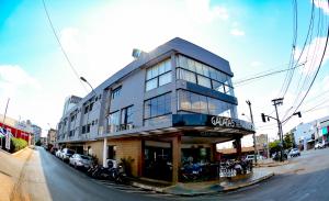 a building on the corner of a street with cars at Galatas Central Hotel in Patos de Minas