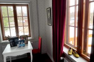 um quarto com uma mesa e duas janelas em Matkustajakoti Ykspihlaja em Kokkola