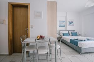 a bedroom with a bed and a table and chairs at Joy Apartment in Rethymno