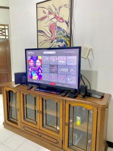 a flat screen tv sitting on top of a wooden cabinet at Fania Villa in Cinengangirang