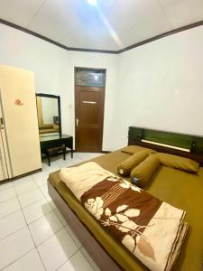 a bedroom with a large bed and a mirror at Fania Villa in Cinengangirang