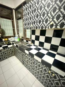 a kitchen with a black and white checkered floor at Fania Villa in Cinengangirang
