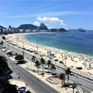 a beach with a lot of people and the ocean at apartamento copa in Rio de Janeiro
