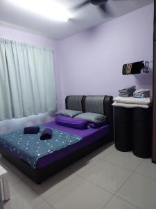 um quarto com uma cama com lençóis roxos e uma janela em Homestay Warisan Violet em Malaca