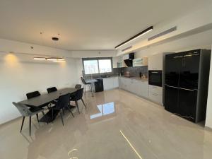 a kitchen with a table and chairs in a room at luxury condo in Qiryat Motzkin