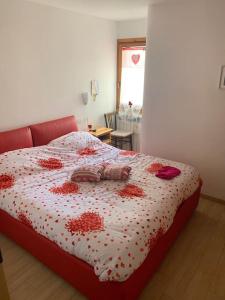 una camera da letto con un letto con fiori rossi di Rocca di Mezzo Casanonnalina a Rocca di Mezzo