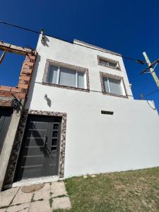 a white building with a door and a cross at Luz del cielo dto PAlta in Necochea