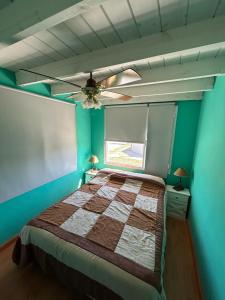 een slaapkamer met een bed en een plafondventilator bij Luz del cielo dto PAlta in Necochea