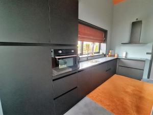 a kitchen with a sink and a stove top oven at Us Eigen Honk in Ternaard