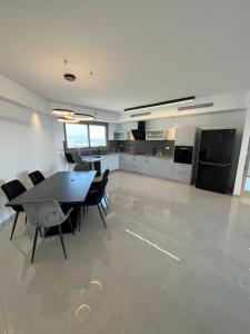a dining room and kitchen with a table and chairs at luxury condo in Qiryat Motzkin
