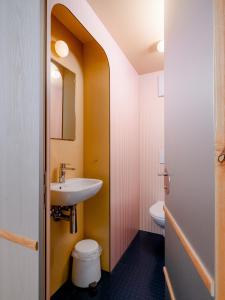 a bathroom with a sink and a toilet at Grand Hotel du Cervin - Auberge de jeunesse wellness in Saint-Luc