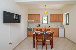 a kitchen with a table and chairs and a refrigerator at M. Houses 5 in Agios Romanos