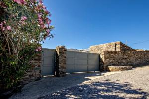 a garage with a gate and a stone wall at M. Houses 5 in Agios Romanos +12 photos