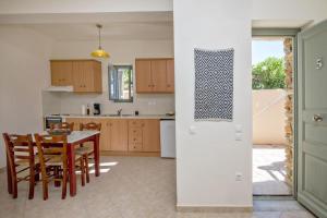 a kitchen and dining room with a table and chairs at M. Houses 5 in Agios Romanos