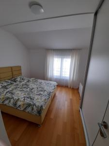 ein leeres Schlafzimmer mit einem Bett und einem Fenster in der Unterkunft Apartman Lena in Banja Luka
