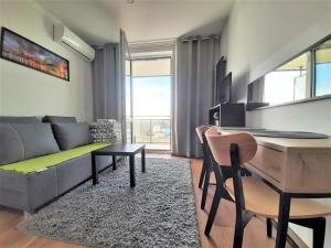 a living room with a couch and a table at Apartament Zachód in Warsaw