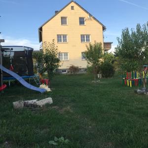 einen Hof mit einem Haus und einem Spielplatz in der Unterkunft Ferienwohnung in Gattendorf