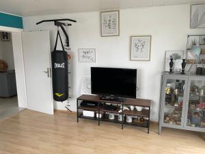 a living room with a flat screen tv and a tv stand at Ferienwohnung in Gattendorf
