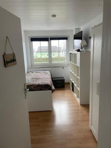 ein kleines Schlafzimmer mit einem Bett und einem Fenster in der Unterkunft Ferienwohnung in Gattendorf