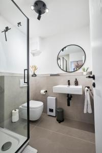 a bathroom with a sink and a toilet and a mirror at Park Avenue - Design Apartment Friesenstraße - 4 Pers - WLAN - Netflix - 65 Zoll TV in Cologne