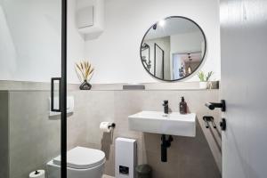 La salle de bains est pourvue d'un lavabo et d'un miroir. dans l'établissement Park Avenue - Design Apartment Friesenstraße - 4 Pers - WLAN - Netflix - 65 Zoll TV, à Cologne