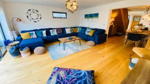 ein Wohnzimmer mit einem blauen Sofa und einem Tisch in der Unterkunft Tregenna House - St Ives, A Beautiful Newly Refurbished 4 Bedroom Family Town House With Alfresco Dining Garden and Private Parking Spaces in St Ives