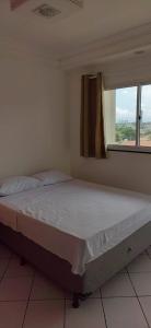 Cette chambre comprend un grand lit et une fenêtre. dans l'établissement Pousada Ponta Negra, à Natal