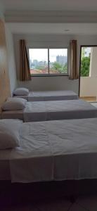um monte de camas alinhadas num quarto em Pousada Ponta Negra em Natal