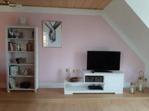 a living room with a television on a white cabinet at Ferienwohnung am Steinwald 